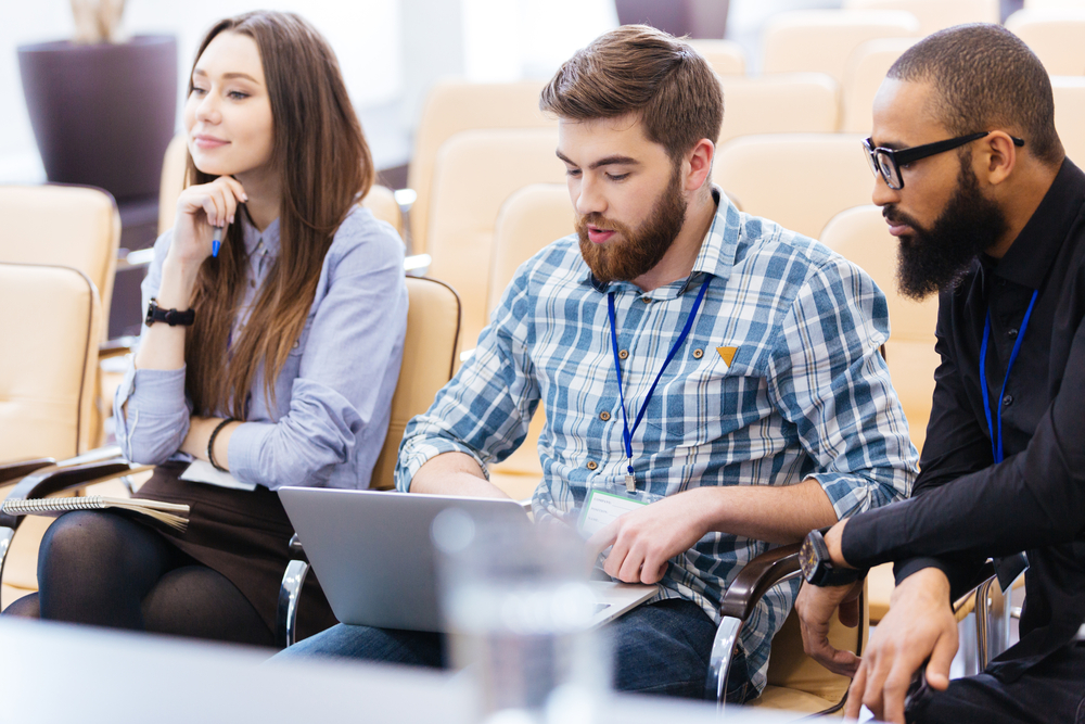Multiethnic group of young business people using laptop sitting on meeting in conference hall Multiethnic group of young business people using laptop sitting on meeting in conference hall