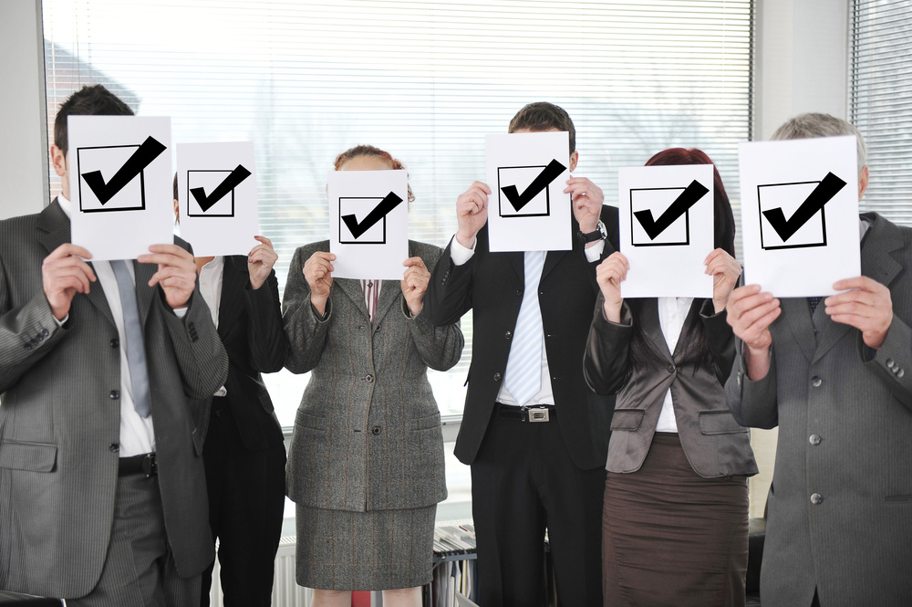 Successful team holding check mark vote sign